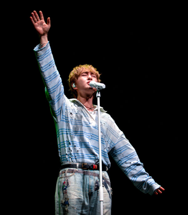 The crowd lights up as Onew tosses paper airplanes into the audience
